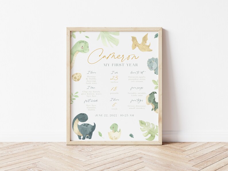 Może przedstawiać: Drukowalny plakat w jasnozielonym, białym i złotym kolorze z motywem dinozaur&oacute;w. Plakat przedstawia ilustrację dinozaura i tekst "Cameron My First Year". Plakat zawiera listę kamieni milowych, takich jak "Uwielbiam" i "Potrafię" z odpowiadającymi im numerami. Plakat zawiera r&oacute;wnież datę "June 22, 2022 10:25 AM".
