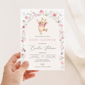Pode incluir: Um convite para um ch&aacute; de beb&eacute; com uma ilustra&ccedil;&atilde;o em aquarela do Ursinho Pooh. O convite &eacute; decorado com elementos florais e inclui o texto "Please join us for a Baby Shower" e os detalhes do evento.