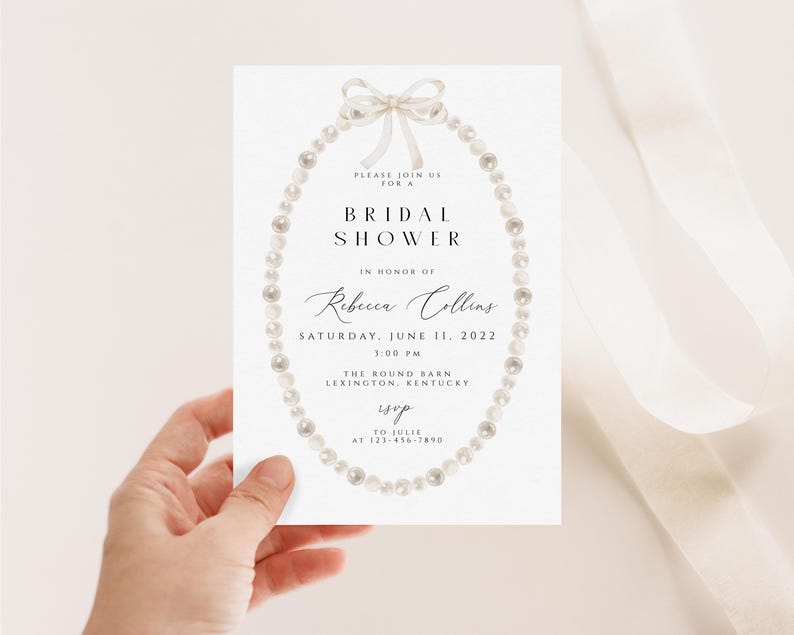 May include: A white bridal shower invitation featuring a pearl necklace and bow illustration. The text reads "Please join us for a Bridal Shower in honour of Rebecca Collins, Saturday, June 11, 2022, 1:00 PM, The Round Barn, Lexington, Kentucky, RSVP to Julie at 123-456-7890."