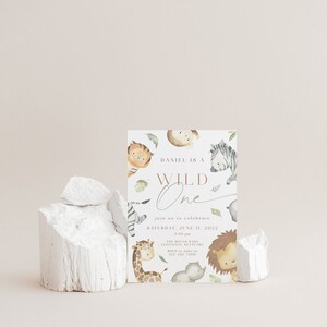 May include: A light brown invitation card with a watercolor illustration of jungle animals. The text reads "Daniel is a Wild One" and includes details for a birthday party on June 11, 2022.