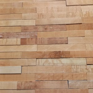 Könnte beinhalten: Eine Wand, die mit einer Holzverkleidung aus dünnen, rechteckigen Holzstücken verkleidet ist. Das Holz ist hellbraun und weist einige Maserungen auf.
