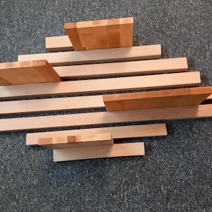 May include: A set of wooden shelves made of natural wood planks. The shelves are arranged in a staggered pattern, creating a unique and modern look.