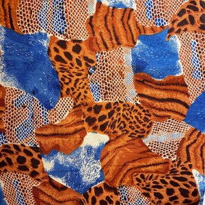 May include: Abstract fabric with a mix of animal print patterns. The design features leopard spots, tiger stripes, and snake scales in shades of brown, orange, blue, and white. The fabric has a textured appearance.