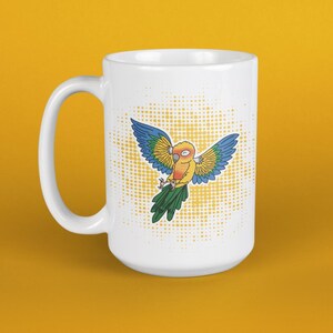 Könnte beinhalten: Weiße Keramik-Tasse mit einem Cartoon-Papageien-Design. Der Papagei hat blaue, gelbe und grüne Federn und ausgebreitete Flügel. Die Tasse hat einen großen Henkel und einen gepunkteten Hintergrund. Die Tasse steht auf einem gelben Hintergrund.