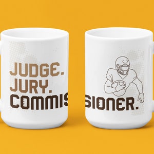 May include: White ceramic coffee mug with a brown graphic of a football player and the text "JUDGE. JURY. COMMISSIONER."
