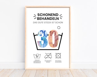 May include: A white framed poster with black text that reads "Schonend Behandeln Das Gute Stück Ist Schon" and a black and white illustration of a washing instruction symbol with the number 30 inside. The number 30 is made up of a 20 Euro bill and a 10 Euro bill. Below the symbol are three more black and white washing instruction symbols with text below each: "Tagliche Handwäsche erforderlich", "Falten Nicht Bügeln", and "Bitte Nicht Schleudern".