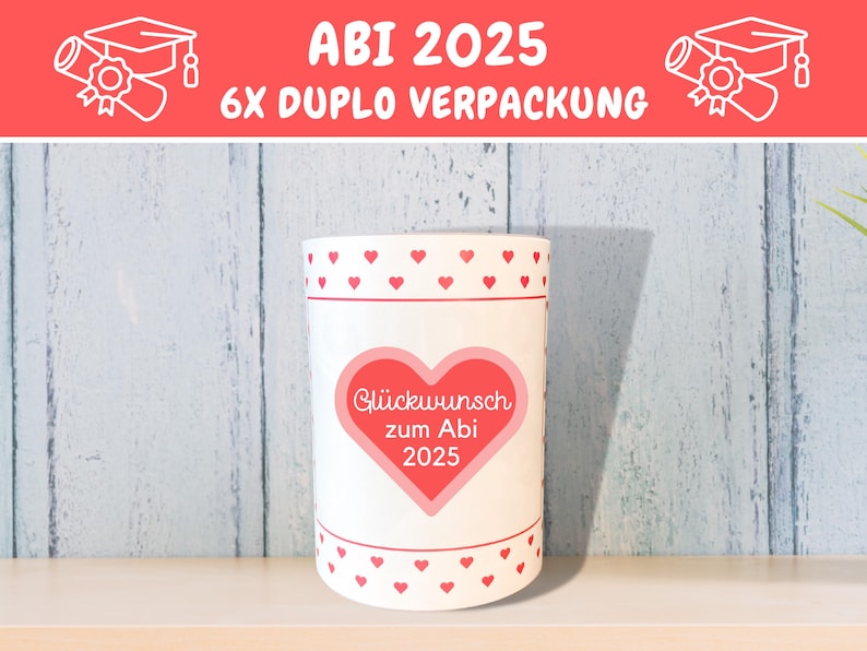 May include: White cylindrical container with a red heart design and the text "Gl&uuml;ckwunsch zum Abi 2025". The container has a red and white polka dot pattern around the top and bottom.