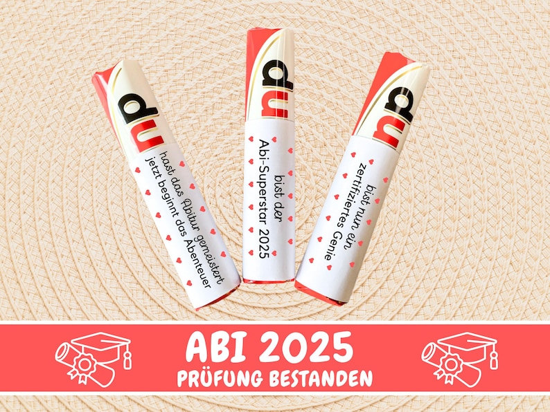 May include: Three white chocolate bars with red and white wrappers. The wrappers have text in German that says "du bist der Abi-Superstar 2025", "du bist nun ein zertifiziertes Genie", and "du hast das Abitur gemeistert jetzt beginnt das Abenteuer". Below the bars is a red banner with white text that says "ABI 2025 PR&Uuml;FUNG BESTANDEN".