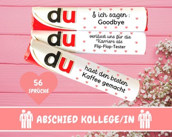 May include: Three white chocolate bars with the word "du" printed on them. The bars are stacked on top of each other. The top bar has the text "& ich sagen: Goodbye" printed on it. The middle bar has the text "verlässt uns für die Karriere als Flip-Flop-Tester" printed on it. The bottom bar has the text "hast den besten Kaffee gemacht" printed on it. There is a pink heart with the text "56 SPRÜCHE" printed on it below the bars. The text "ABSCHIED KOLLEGE/IN" is printed below the heart. There are two stick figures with ties on either side of the text.