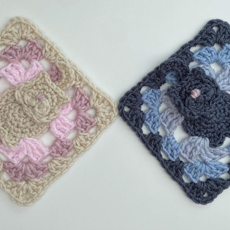 May include: Two crocheted squares, one in pink, beige, and white, and the other in blue, gray, and white.