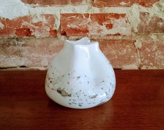 May include: White ceramic vase with a textured, speckled surface and a unique, organic shape.