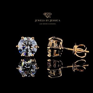 May include: Two gold stud earrings with round, clear lab grown diamonds. The earrings are set against a black background. The text 'Jewels by Jessica Lab Grown Diamonds' is displayed above the earrings.
