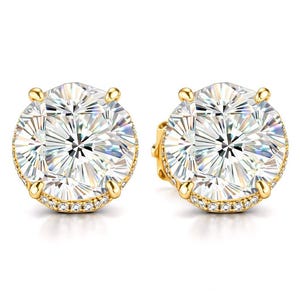 May include: A pair of gold stud earrings with large, round, clear gemstones. The earrings have a halo of small, clear stones around the main gem and are set in a gold setting. The text "concept design" is in the bottom right corner.