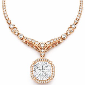 May include: A rose gold necklace featuring a large, square-cut diamond pendant surrounded by smaller diamonds. The necklace has a delicate, ornate design with additional diamond accents along the chain.