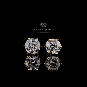 May include: A pair of gold stud earrings with round, clear lab-grown diamonds. The earrings are set in a classic prong setting. "Jewels by Jessica Lab Grown Diamonds" is written in the top center of the image.