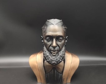 May include: A 3D printed bust of a person with a beard and a bow tie. The bust is painted in black and bronze.