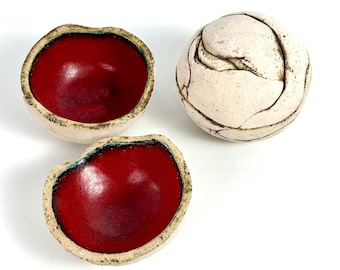 Platos decorativos antiguos hechos a mano por artesanos, firmados, con forma de orbe e interior naranja y rojo.