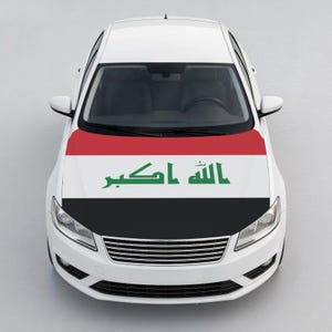 May include: A white sedan featuring a hood wrap displaying the national flag of Iraq. The flag design consists of horizontal red, white, and black stripes with green Arabic script centered on the white stripe. The car has a silver front grille.