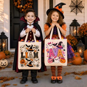 May include: Two off-white canvas tote bags featuring Halloween-themed graphics. One bag displays the name LIAM in patterned block letters surrounded by ghosts, pumpkins, and witch hats. The other bag shows the name AVA in colorful letters with ghosts, pumpkins, and a witch hat.