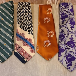 May include: Four vintage neckties in a row. The ties have various patterns and colors, including green with white and yellow circles, black and white geometric shapes, orange with a floral design, and purple with a dragon pattern.