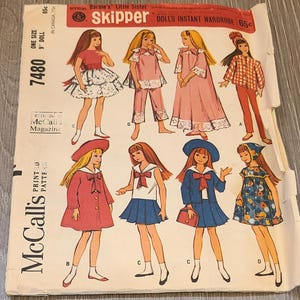 May include: Vintage McCall's sewing pattern for Barbie's little sister, Skipper, featuring a variety of doll outfits. The pattern includes illustrations of the doll in different outfits, including dresses, coats, and pajamas. The pattern is marked as one size for a 9-inch doll.