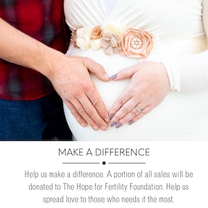 May include: A couple's hands form a heart shape over a pregnant belly. The woman is wearing a white dress with a floral sash. The man is wearing a red and black plaid shirt. The text "MAKE A DIFFERENCE" is at the bottom of the image.