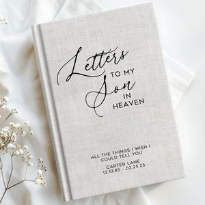 May include: A light gray journal with the text "Letters to My Son in Heaven" in elegant script. The bottom of the journal reads "All the things I wish I could tell you" and includes a name and dates.