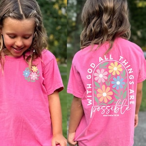 Christian youth shirt with pastel floral design and the phrase With God All Things Are Possible printed on the front and back. Inspirational faith based graphic tee for girls and kids. Available in Comfort Colors adult t shirts, long sleeve shirts, sweatshirts, and youth short sleeve tees. Soft garment dyed Christian shirt perfect for church, youth group, school, everyday faith wear, and Christian gifts.