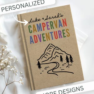 May include: A personalized journal with the text "Luke & Sarah's CAMPERVAN ADVENTURES" in colorful letters. The cover features a black and white mountain and river illustration on a tan background. The word "PERSONALIZED" is at the top.