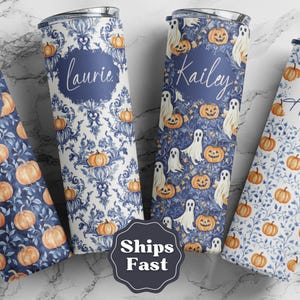 May include: Four personalized stainless steel tumblers with Halloween-themed designs. The tumblers feature patterns of pumpkins, ghosts, and floral motifs in blue and orange. Each tumbler has a name in a circular frame.
