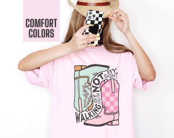 May include: Pink oversized t-shirt with a graphic of cowboy boots and the text "Walking by faith not by sight".