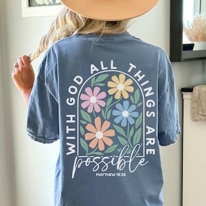 Pastel floral Christian shirt with the phrase With God All Things Are Possible printed on both front and back. Inspirational faith based graphic apparel available in Comfort Colors adult short sleeve t shirts, long sleeve shirts, sweatshirts, and youth short sleeve tees. Soft garment dyed Christian shirt perfect for church, Bible study, everyday faith wear, and Christian gifts.