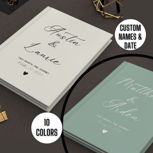 K&ouml;nnte beinhalten: Zwei personalisierte Hardcover-Journale mit wei&szlig;er Schrift auf der Vorderseite. Das erste Journal ist wei&szlig; mit schwarzer Schrift und dem Text "Austin & Laurie Two Hearts, One Journey October 23, 2022". Das zweite Journal ist hellgr&uuml;n mit wei&szlig;er Schrift und dem Text "Matthew & Arden Two Hearts One Journey".