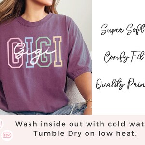 May include: Purple t-shirt with the word "Gigi" in colorful block letters. The shirt is super soft, comfy, and has a quality print. Wash inside out with cold water and tumble dry on low heat.