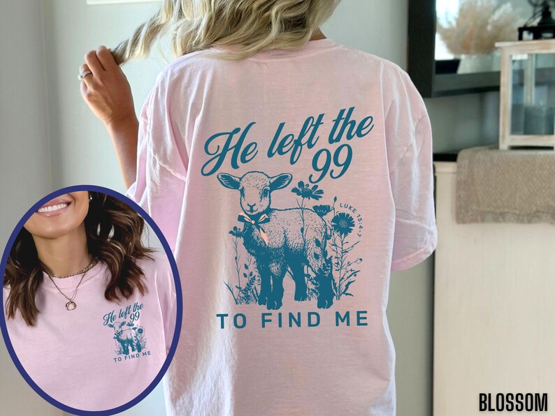 May include: A pale pink t-shirt featuring the teal text "He left the 99 TO FIND ME" and a lamb illustration with flowers. The text "Luke 15:4-7" is also included. The shirt is a relaxed fit, ideal for everyday wear.