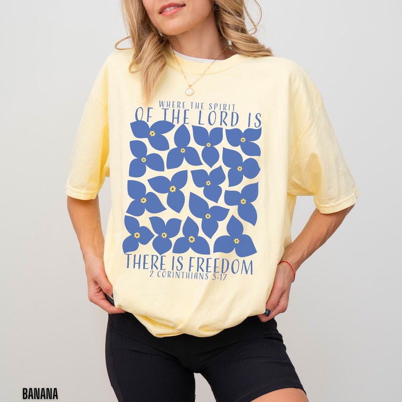 May include: A yellow t-shirt with a blue floral design and the text "Where the spirit of the Lord is there is freedom 2 Corinthians 3:17".
