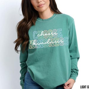 May include: A light green long-sleeved t-shirt with the text "Choose Kindness" in rainbow colors.