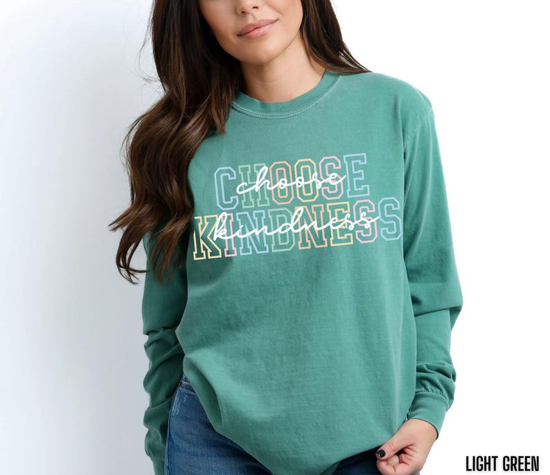 May include: A light green long-sleeved t-shirt with the text "Choose Kindness" in rainbow colors.