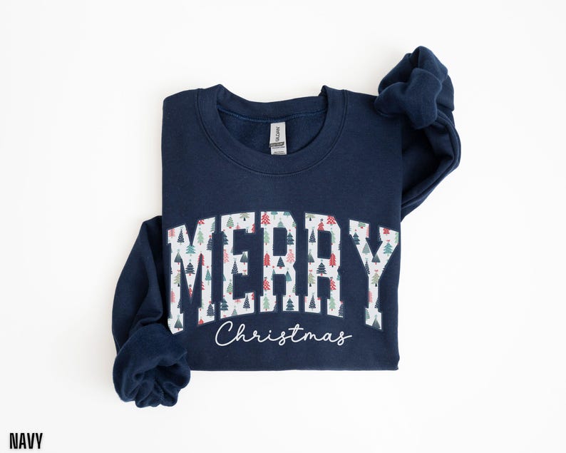 May include: A navy blue sweatshirt with a white "Merry Christmas" graphic featuring a pattern of colorful Christmas trees.