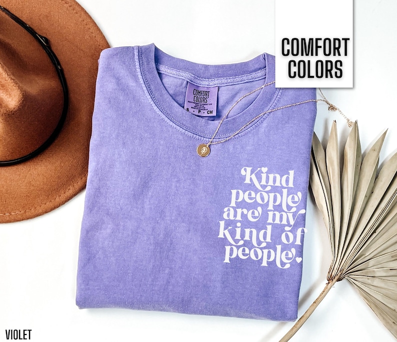 May include: Purple t-shirt with the text "Kind people are my kind of people." in white lettering. The shirt has a distressed look and is made of a soft, comfortable fabric.