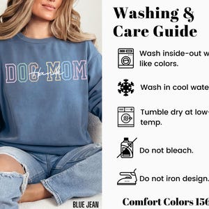May include: A blue sweatshirt with the text "DOG MOM" in rainbow colors. The image includes a washing and care guide with instructions for washing inside-out, washing in cool water, tumble drying at low temperature, not bleaching, and not ironing the design. The text "Comfort Colors 1566" is also included.