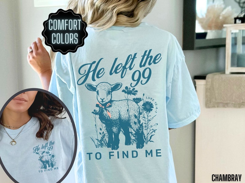 May include: Pale blue t-shirt with a teal illustration of a lamb, flowers, and the text "He left the 99 to find me." The shirt is made of chambray fabric and features the words "Comfort Colors."