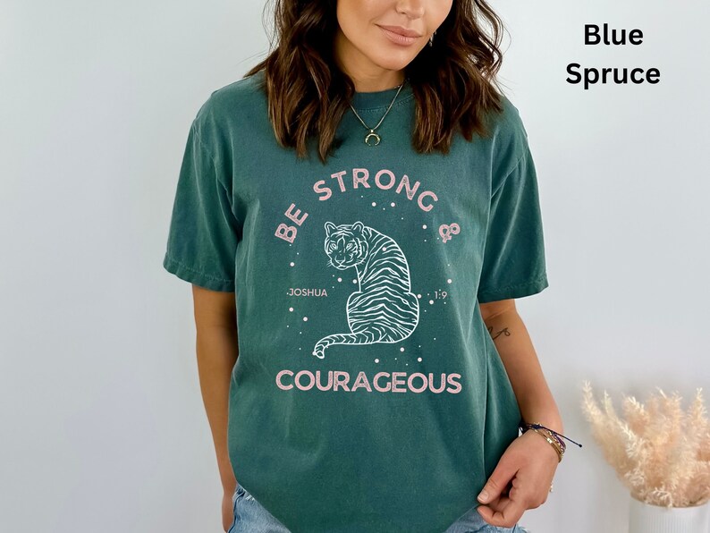 May include: A teal blue t-shirt with a white graphic of a tiger with the text "Be Strong & Courageous" and "Joshua 1:9".