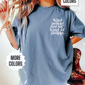 May include: A blue t-shirt with the text "Kind people are my kind of people." printed on the front. The shirt is shown on a model wearing blue jeans.