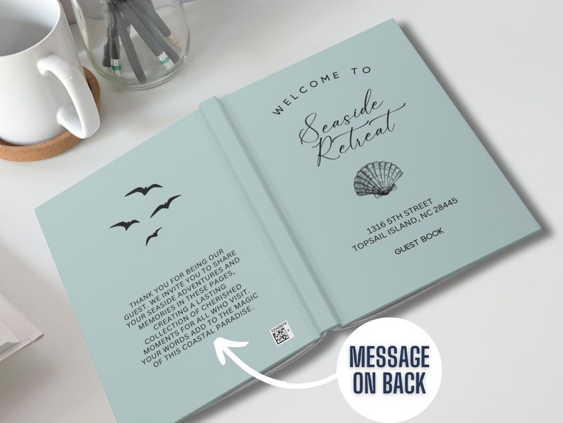 May include: A light blue guest book with the words "Welcome to Seaside Retreat" and a seashell illustration. The address "1316 5th Street Topsail Island, NC 28445" and the words "Guest Book" are printed on the cover. The back cover has a message that reads "Thank you for being our guest. We invite you to share your seaside adventures and memories in these pages, creating a lasting collection of cherished moments for all who visit. Your words add to the magic of this coastal paradise."