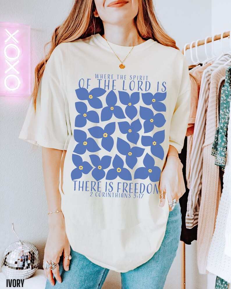 May include: A white t-shirt with a blue floral design and the text "Where the Spirit of the Lord is There is Freedom 2 Corinthians 3:17".