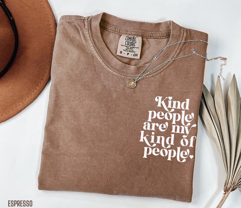 May include: A brown t-shirt with the text "Kind people are my kind of people" in white lettering. The shirt is made of a soft, comfortable material.