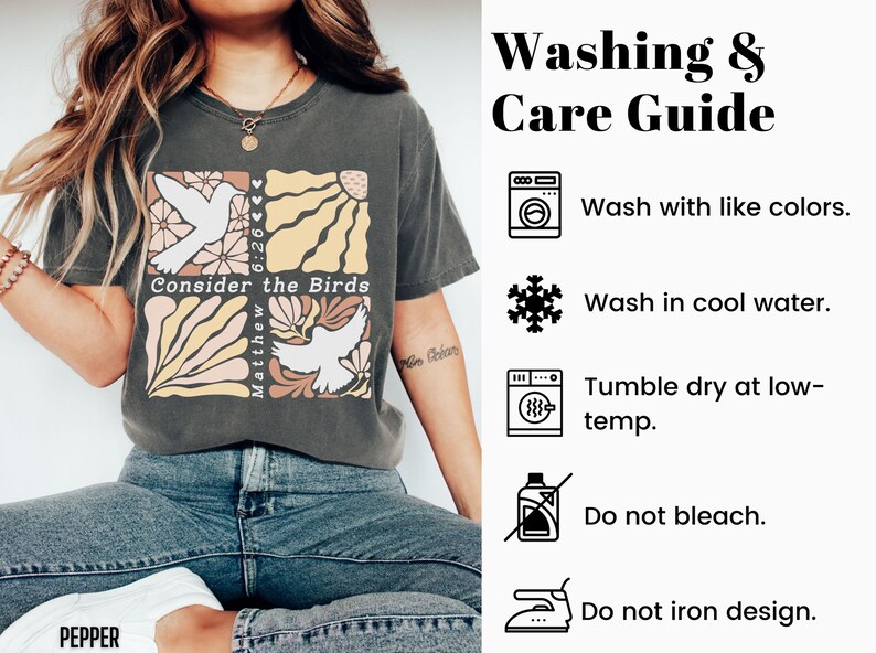 Op de afbeelding: Een grijs T-shirt met een grafisch ontwerp met een duif, bloemen en de tekst "Consider the Birds" en "Matthew 6:26". De afbeelding bevat ook een was- en onderhoudsgids met instructies voor het wassen, drogen en strijken van het shirt.