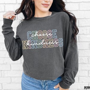 May include: A dark gray long-sleeved shirt with the text "CHOOSE KINDNESS" in rainbow colors.