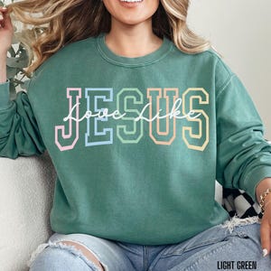 May include: A light green sweatshirt with the words "Love Like Jesus" in rainbow coloured letters.